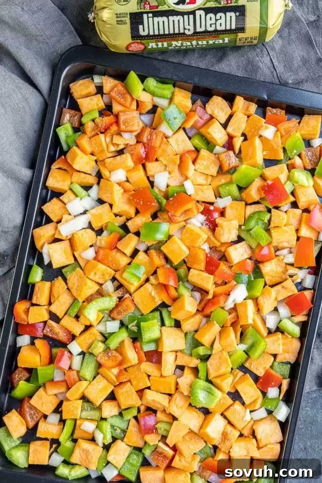 Sweet Potato Hash with Jimmy Dean sausage on a sheet pan, ready for baking.