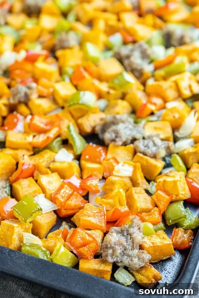 A close-up of Sweet Potato Hash with perfectly cooked peppers and sausage.