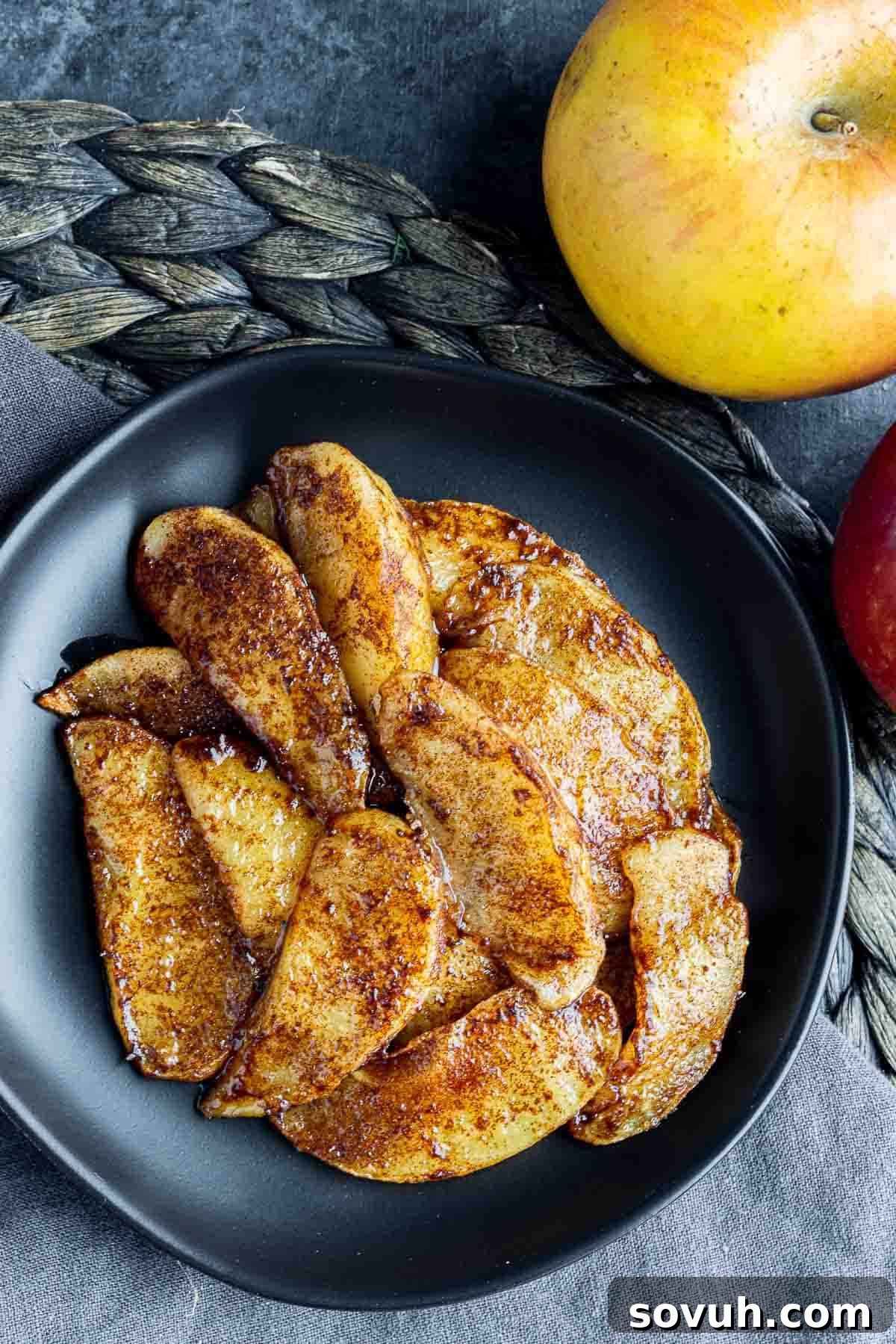A beautiful presentation of air fryer baked apple slices on a plate with a fresh apple on the side, highlighting their rustic charm.