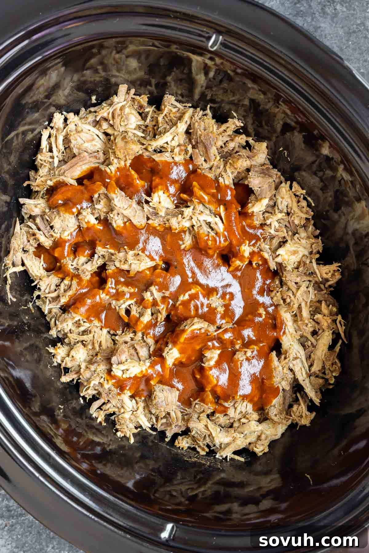 shredded Slow Cooker BBQ Pulled Pork in slow cooker with bbq sauce