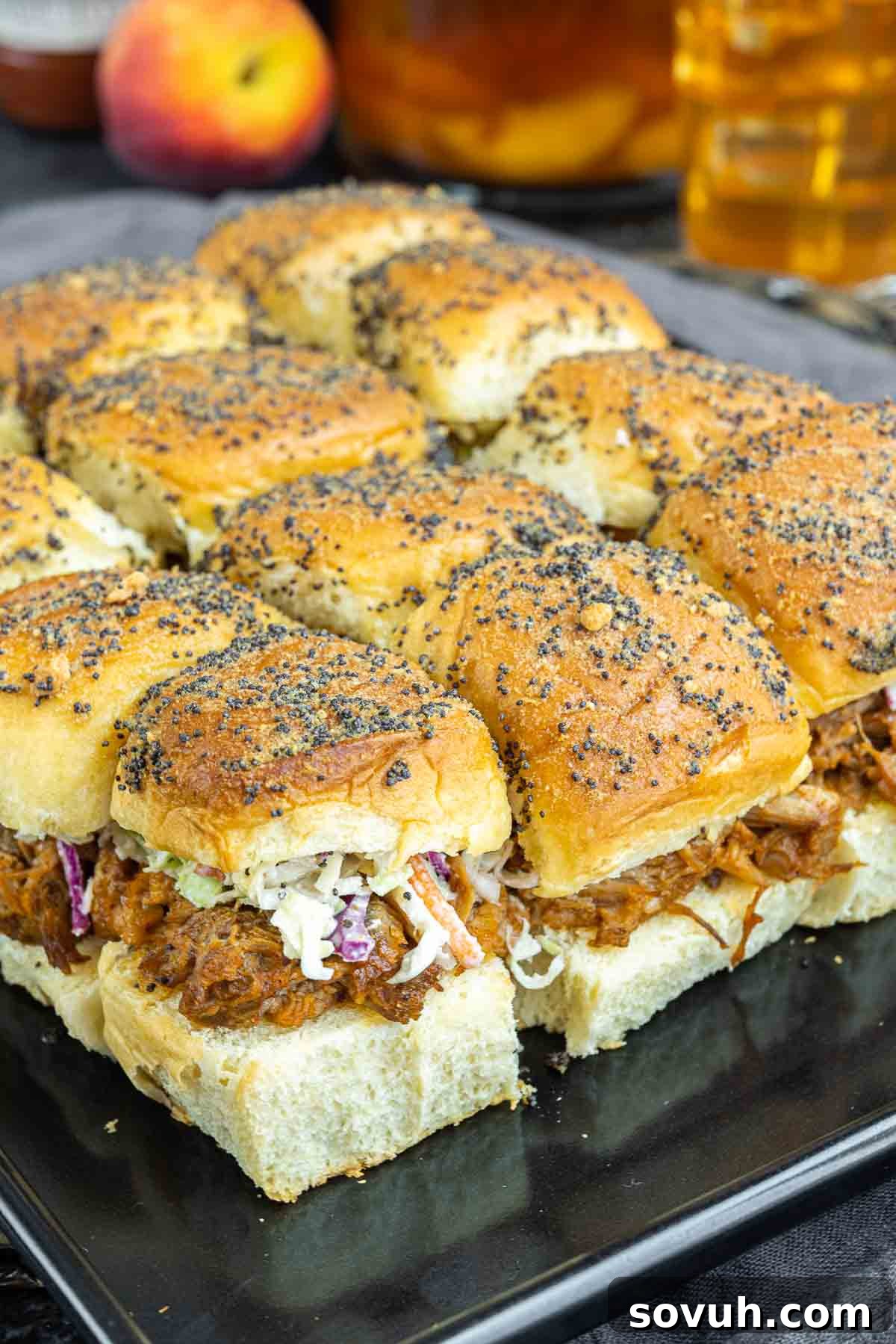 Baked BBQ Pulled Pork Sliders arranged on a sheet pan, ready to be topped with coleslaw and served