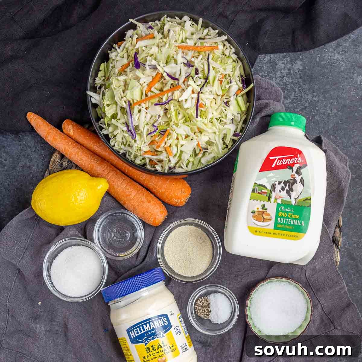 Fresh ingredients laid out for making Southern Coleslaw, including cabbage, carrots, and dressing components