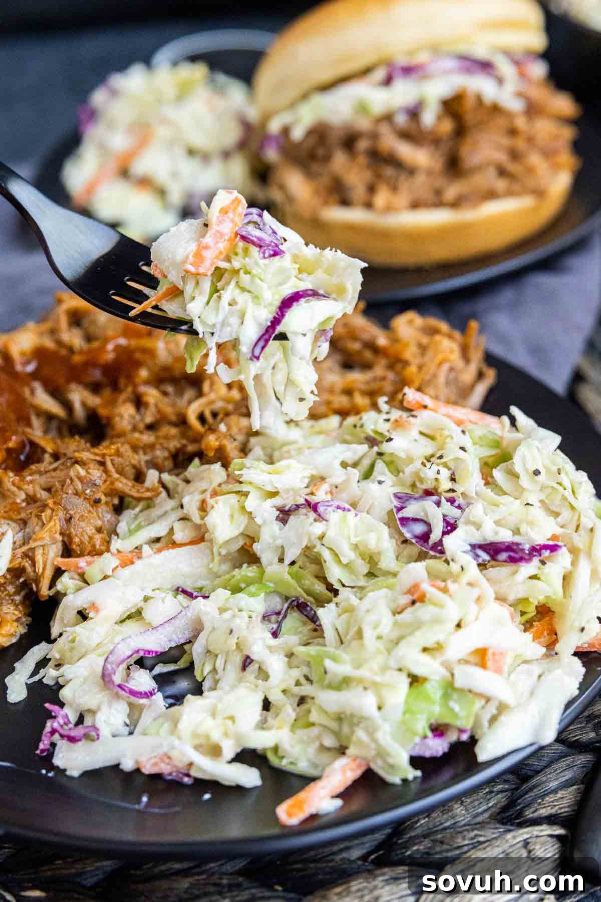 Southern Coleslaw served on a black fork, showing its creamy texture