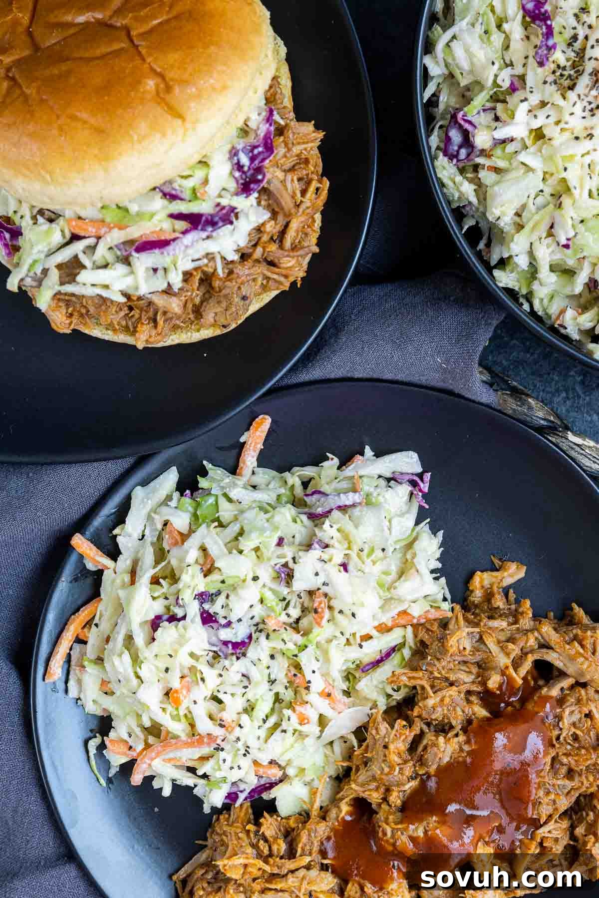 Southern Coleslaw served on a black plate alongside a pulled pork sandwich, a classic pairing
