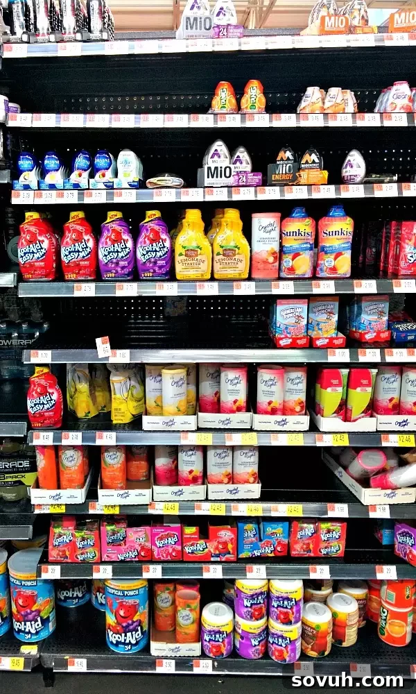 In-store display of Kool-Aid Easy Mix varieties at Walmart, highlighting Cherry, Tropical Punch, and Grape flavors for easy summer drinks.