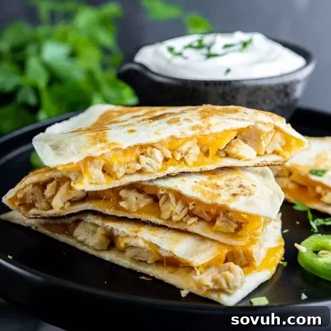 Three stacked ingredients to make Chicken Quesadillas on a black plate