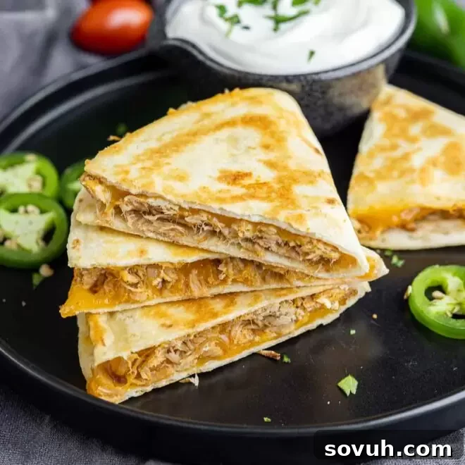 Pulled Pork Quesadillas served on a black plate with jalapeno slices