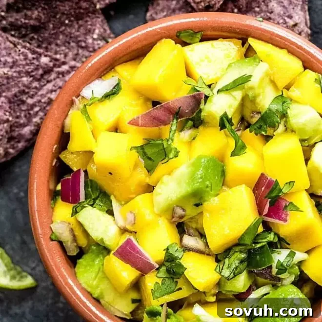 Bowl of fresh, vibrant Mango Salsa with avocado and red onion