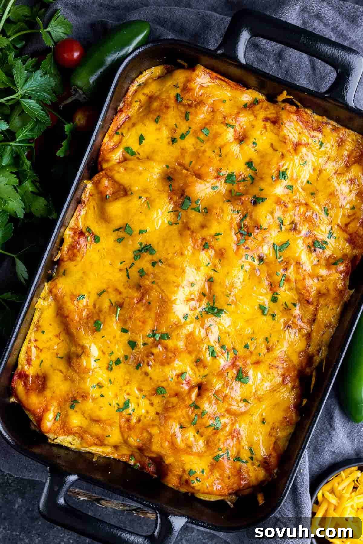 The finished Pulled Pork Enchilada Casserole, hot and cheesy, in a baking dish.