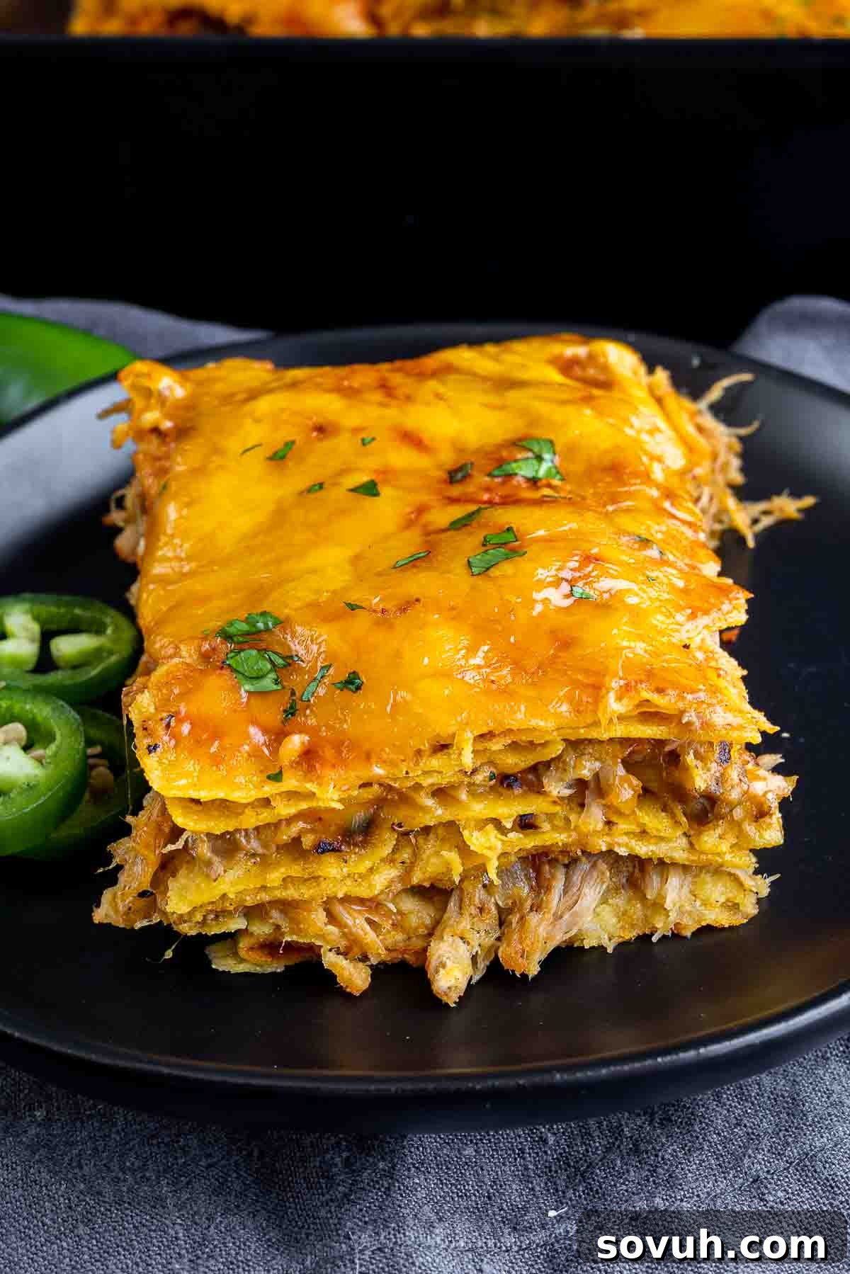 A serving of Pulled Pork Enchilada Casserole on a plate, garnished with fresh cilantro.