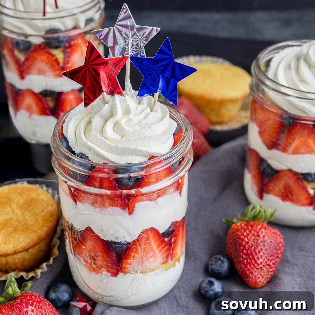 Festive 4th of July cupcakes layered in a jar with fresh fruit and whipped cream, ready for a summer party.