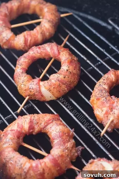 Crispy Bacon Wrapped Sriracha Coated Onion Rings, an irresistible grilled appetizer.