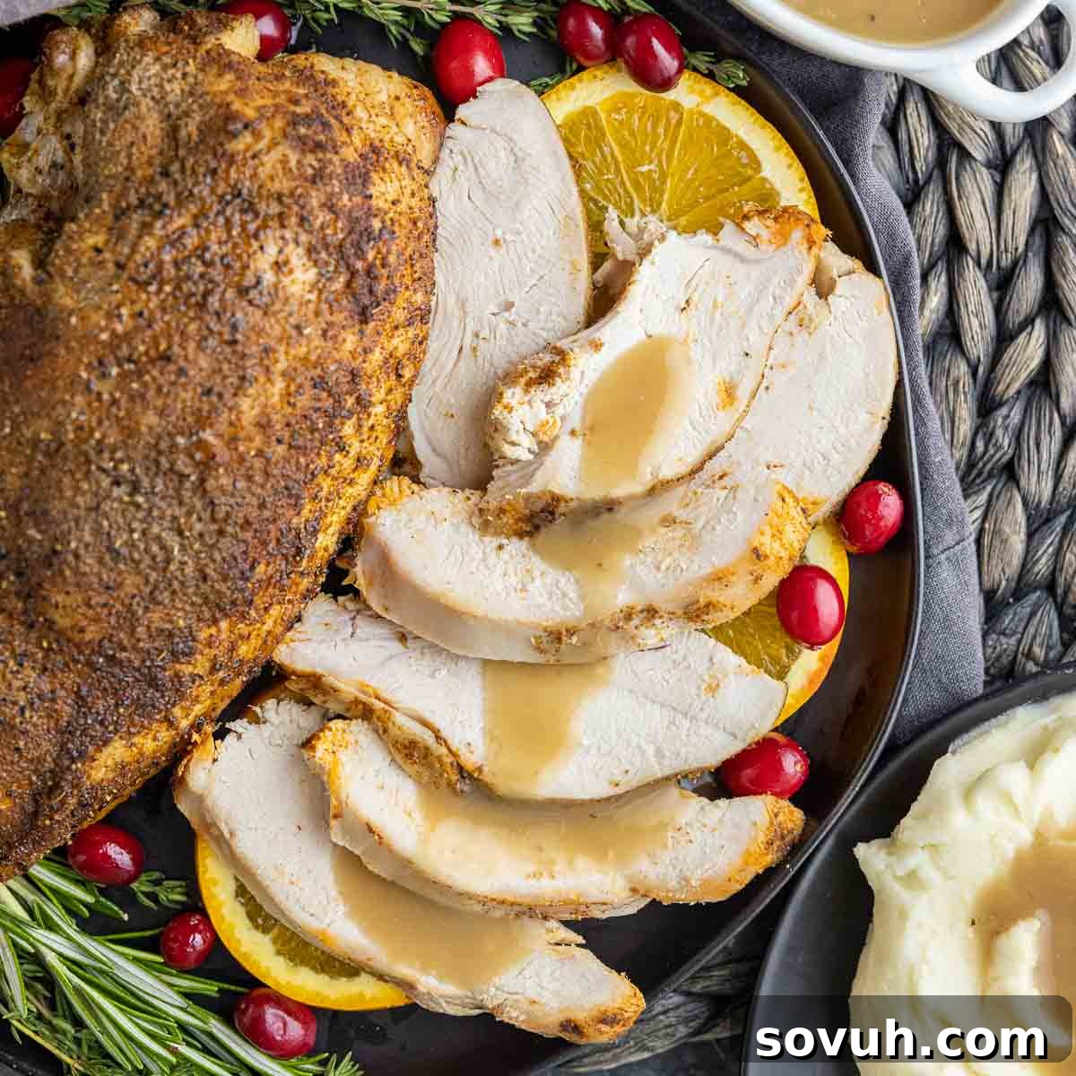 sliced turkey breast with gravy on a black plate