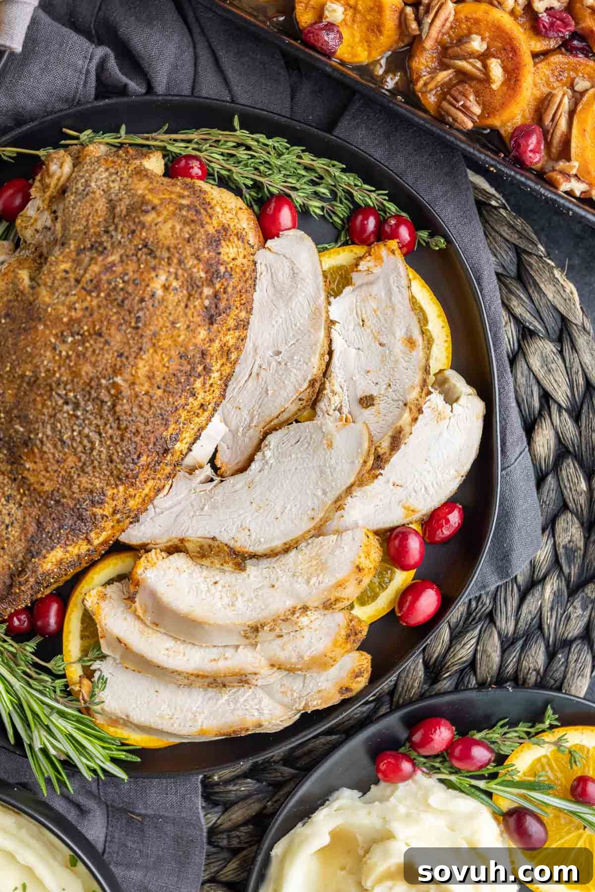 Thanksgiving turkey breast on a black platter with sides