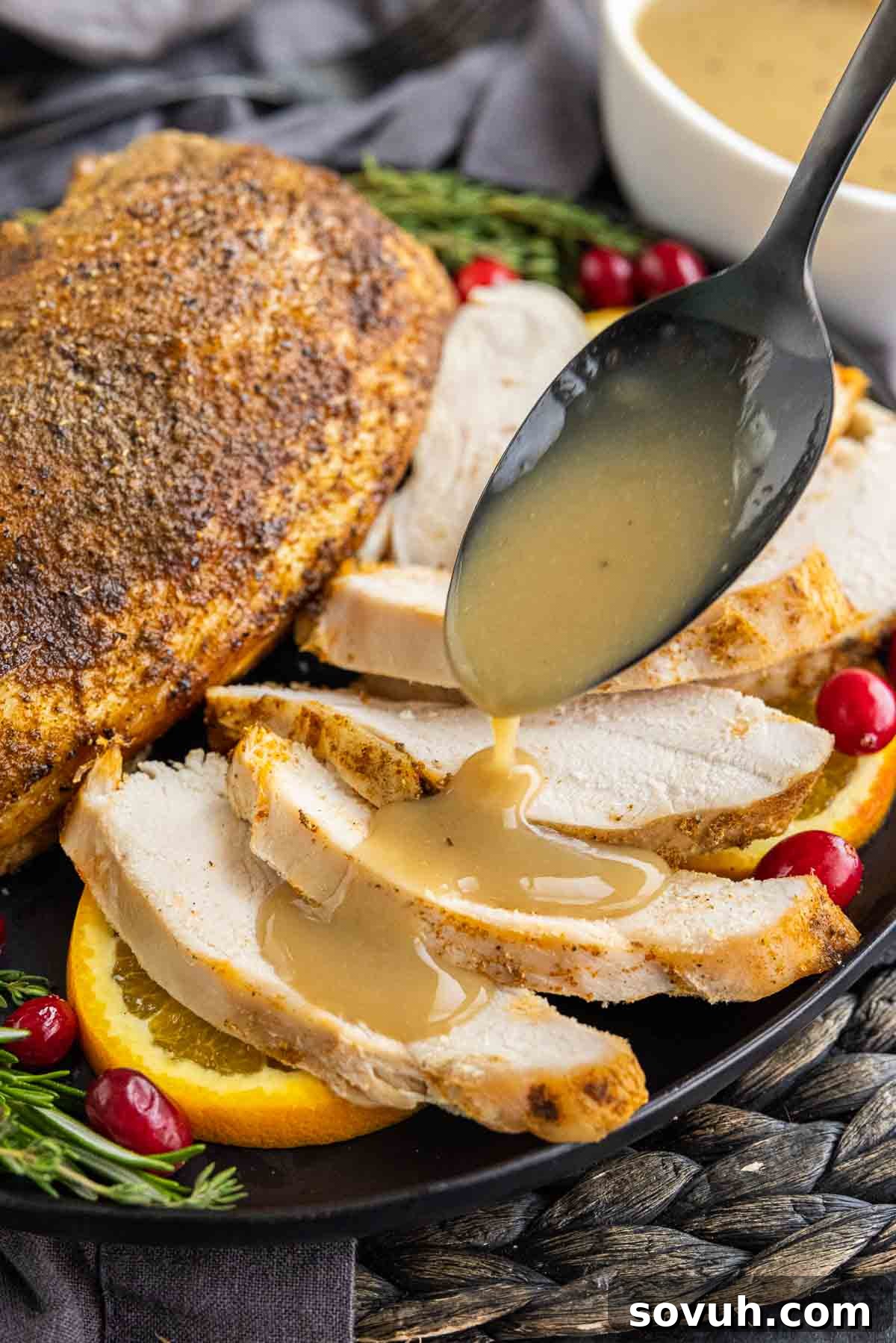 Turkey Gravy on a spoon drizzled over turkey breast