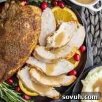 sliced turkey breast with gravy on a black plate