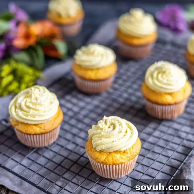 Lemon cupcakes on a cooling rack, showcasing their vibrant yellow color and fluffy frosting.