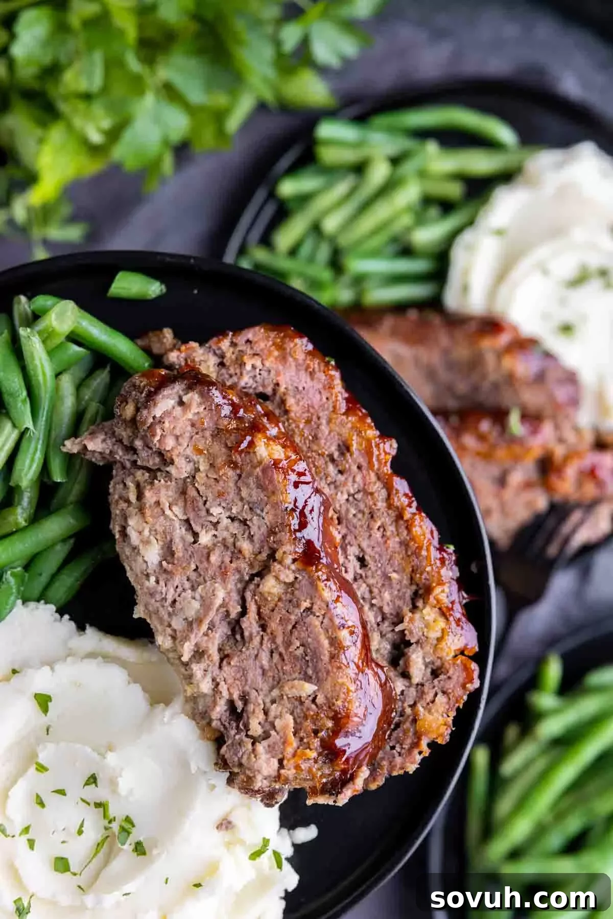 A beautifully sliced easy meatloaf, drizzled with glaze and ready for serving