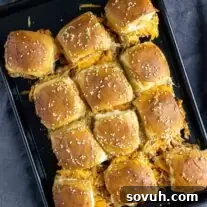Delicious baked BBQ chicken sliders on a baking sheet, ready to be served.