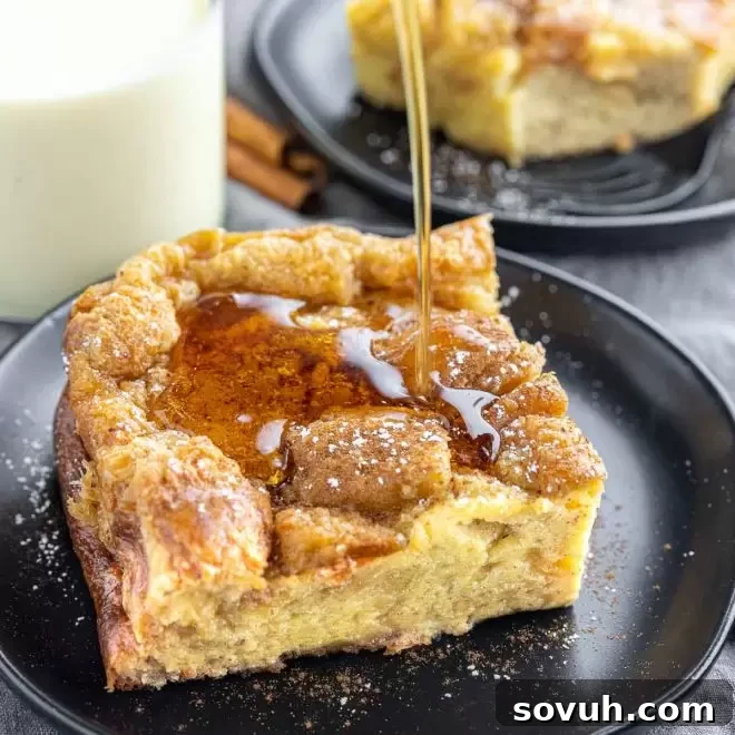 Syrup being generously poured over a golden Eggnog French Toast Bake, highlighting its festive appeal.