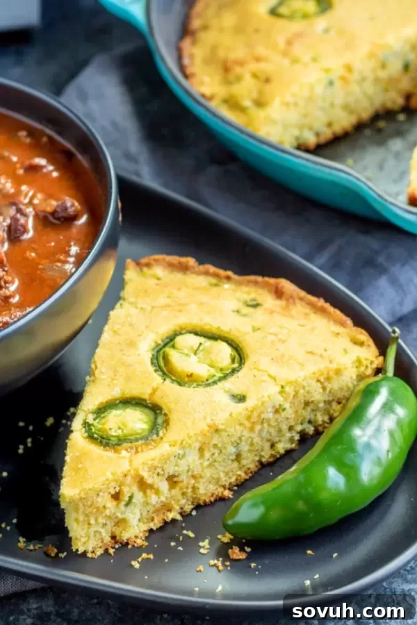 Hearty chili served with generous slices of spicy Jalapeno Cheddar Cornbread in a rustic setting.