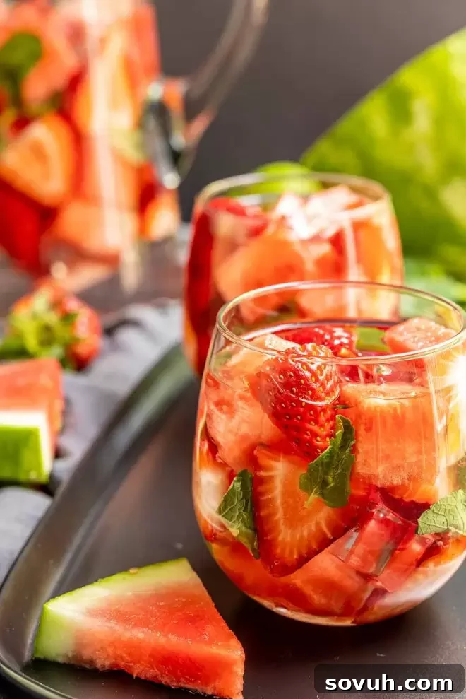Close-up of strawberry watermelon infused water, showcasing fresh fruit chunks at the bottom