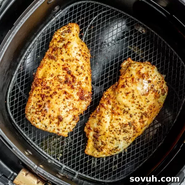 Air Fryer Chicken Breast in air fryer, showing golden-brown and perfectly cooked fillets.