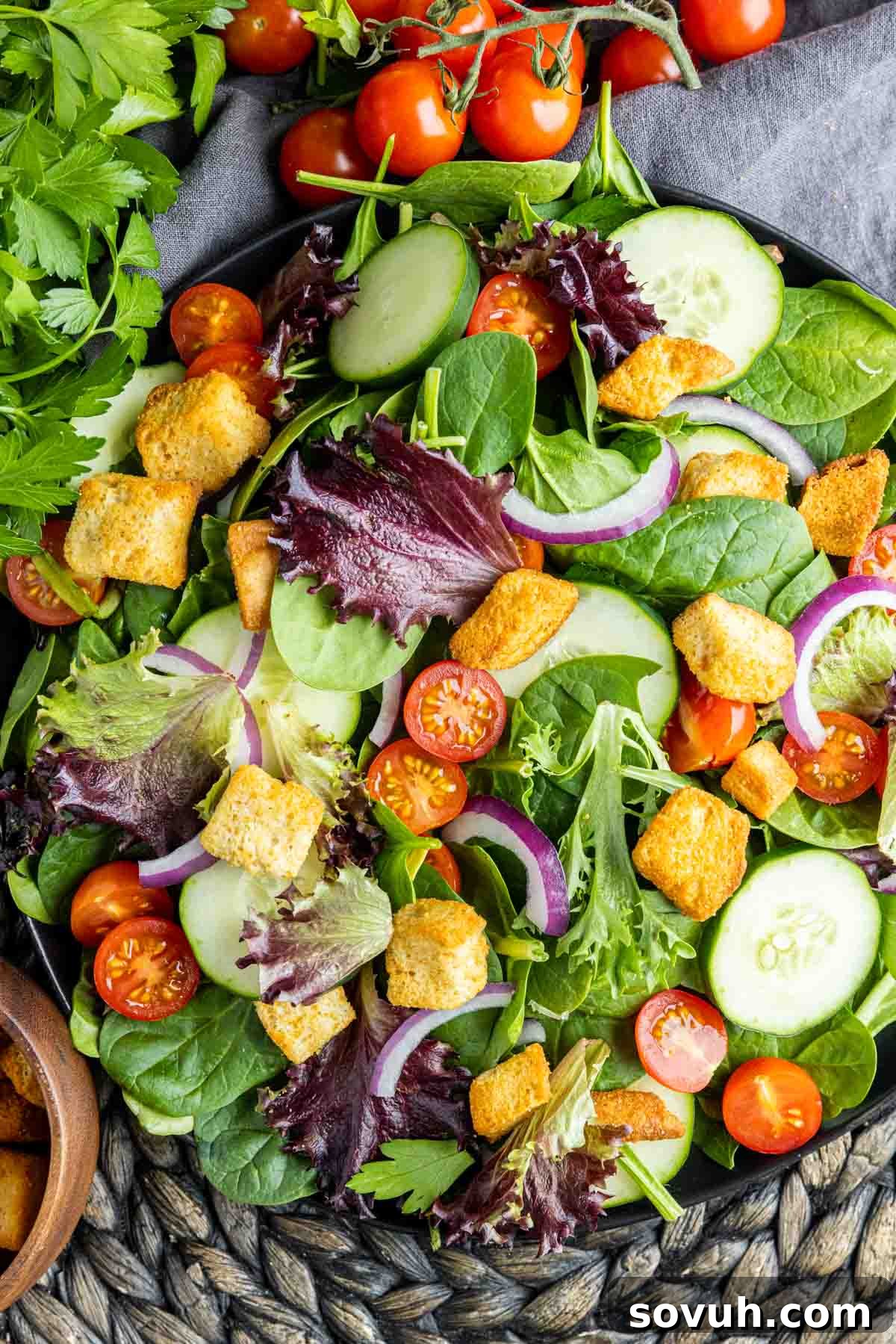 mixed green salad with colorful tomatoes, red onions, and crispy croutons