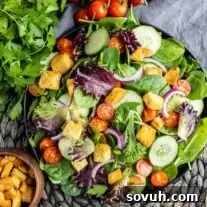 top down view of mixed green salad in black bowl