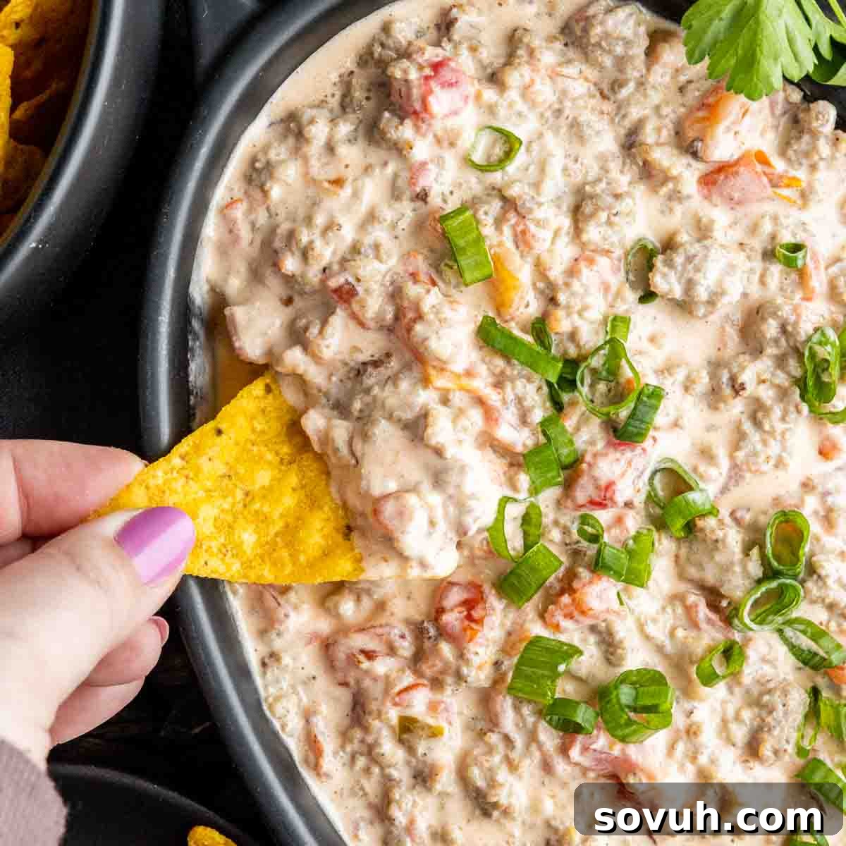Sausage Cream Cheese Dip served with a chip, ready to be enjoyed.