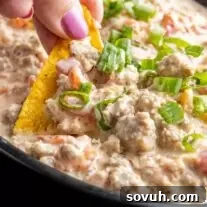 Sausage Cream Cheese Dip on a chip, ready to eat.