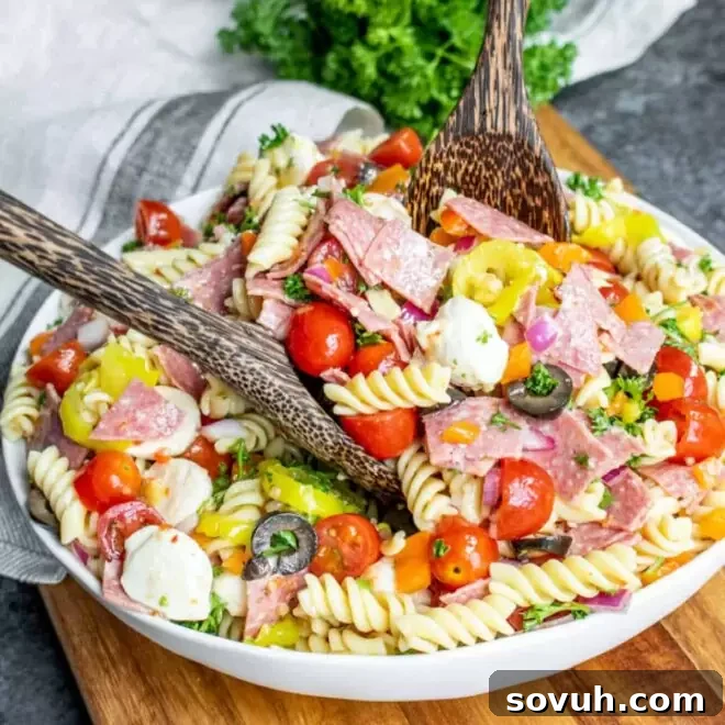 Italian Pasta Salad in a white bowl with wooden serving spoons