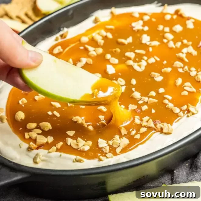 Dipping into Caramel Apple Dip, showcasing its smooth texture.
