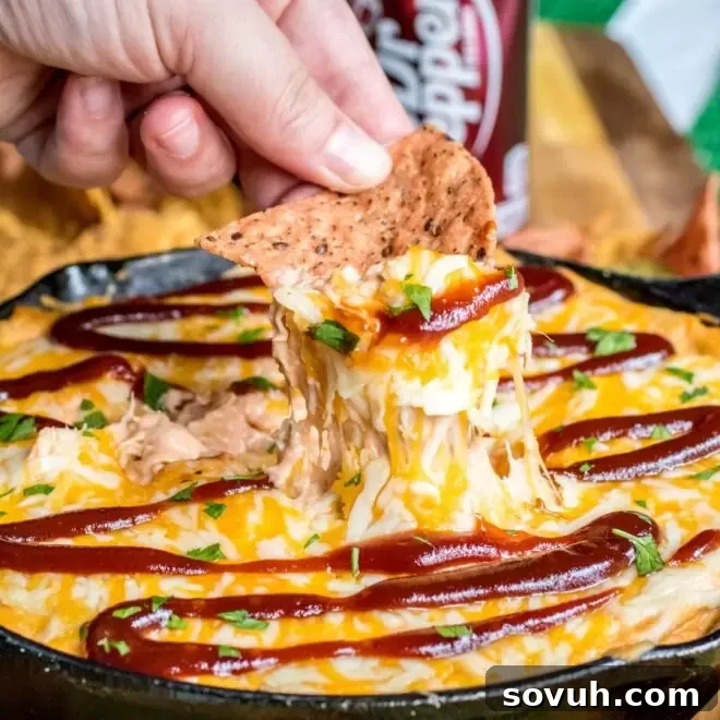 Chip scooping up Dr Pepper BBQ chicken dip.