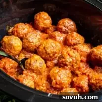 Frozen Meatballs in the Crock Pot with spoon in it