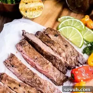 Sliced grilled skirt steak, accompanied by sweet peppers and fresh lime wedges, showcasing a perfect summer meal.
