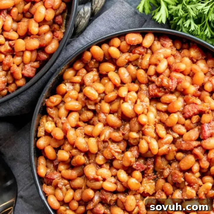 Close-up view of a bowl generously filled with homemade Instant Pot Baked Beans, mixed with savory pieces of bacon or ham.