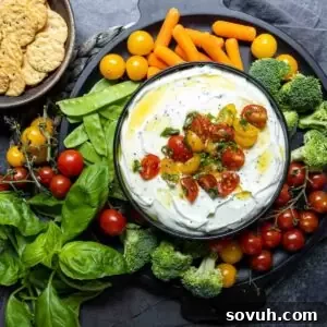 Whipped Ricotta and Tomato Dip presented in a bowl on a colorful vegetable platter, ready for dipping.