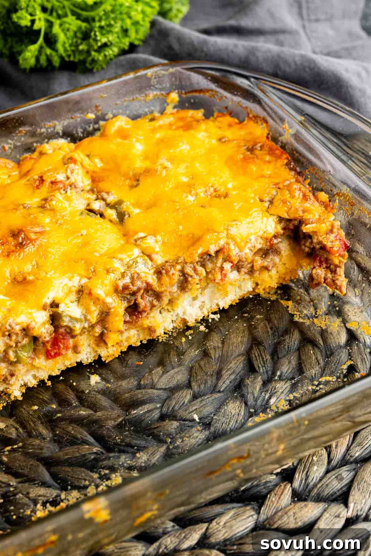 A full John Wayne Casserole dish, perfectly baked with melted cheese, showcasing the layers of meat and creamy topping beneath.