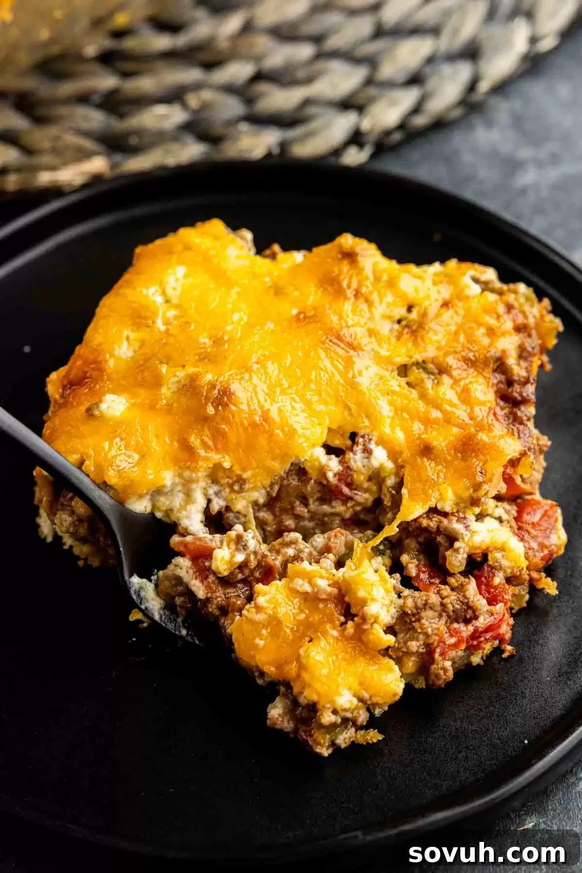 A close-up shot of a John Wayne Casserole on a black plate, emphasizing its texture and layers.
