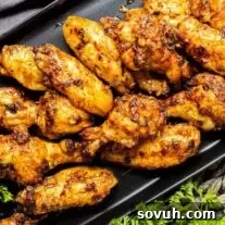 Honey Garlic Chicken Wings on a black plate with parsley.