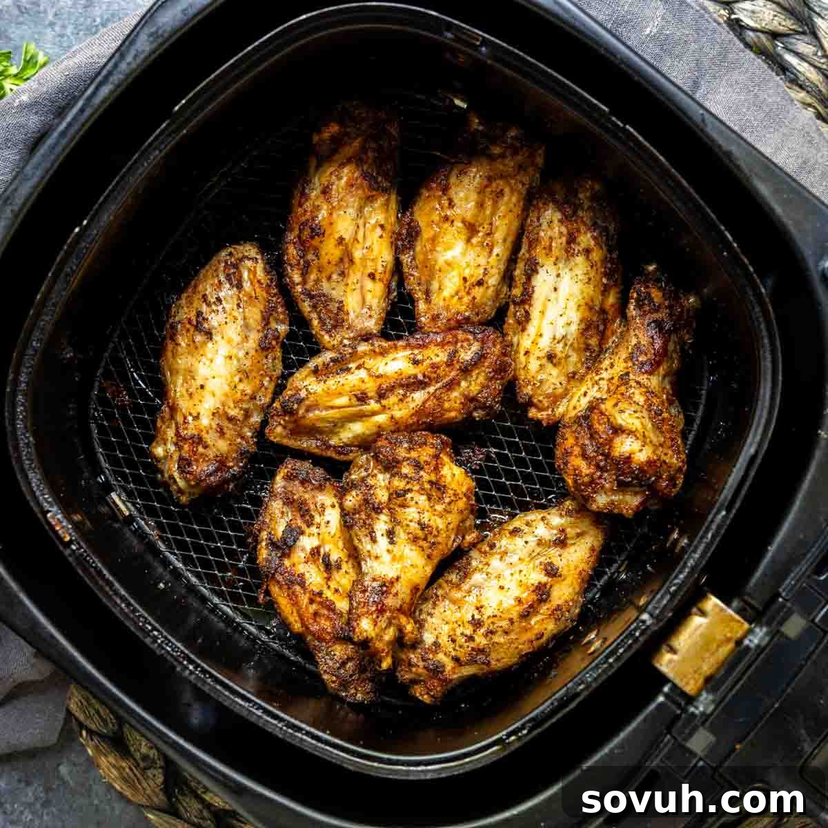 Crispy Frozen Chicken Wings in an Air Fryer basket, ready to be served.