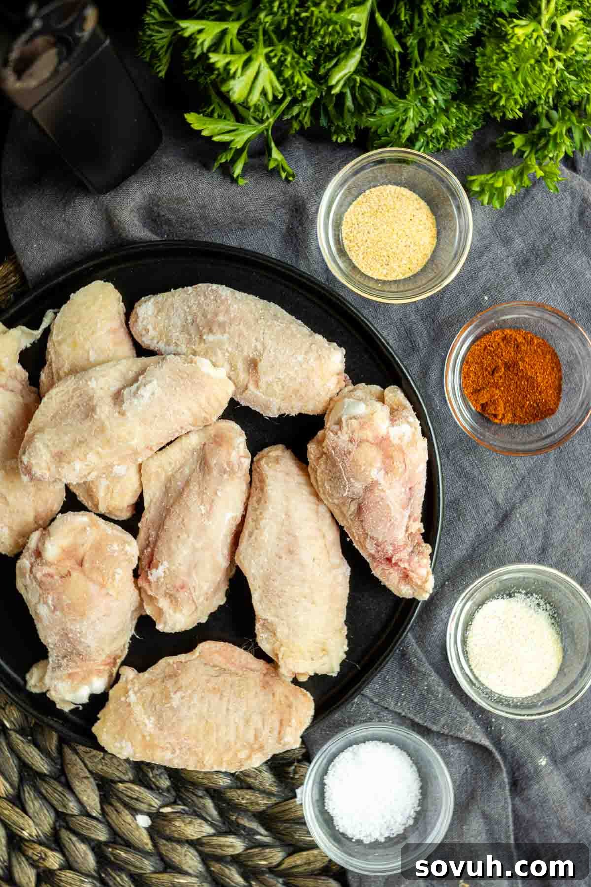Plated Frozen Chicken Wings from the Air Fryer, garnished with spices and herbs.