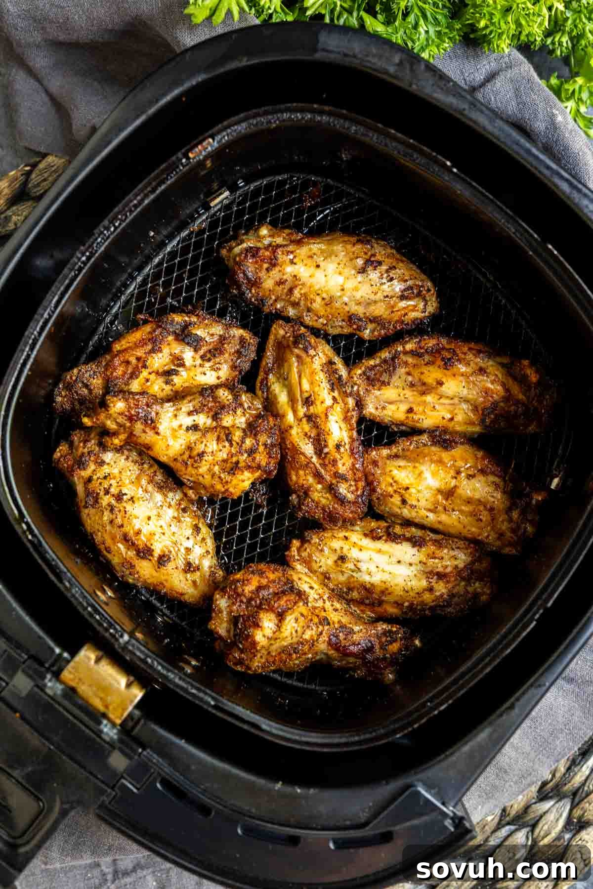 Seasoned chicken wings returned to the air fryer basket for final cooking.