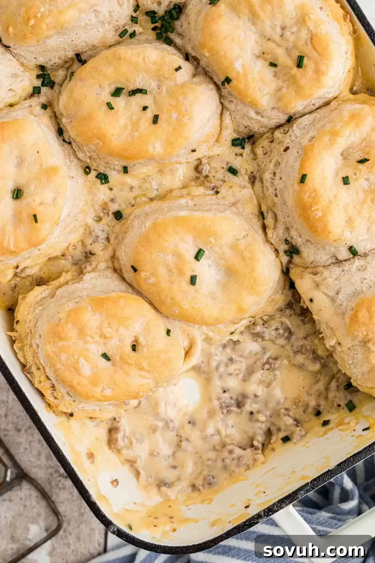 A casserole dish filled with baked Biscuits and Gravy Casserole, fresh out of the oven.