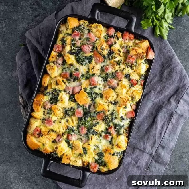 A tantalizing slice of Gruyère, Ham, and Spinach Strata, showcasing layers of cheesy goodness and fresh spinach, ready to be enjoyed.