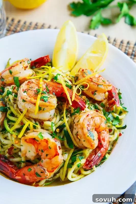 A vibrant dish of fresh zucchini noodles tossed with aromatic basil almond pesto and juicy cherry tomatoes, a perfect light pasta alternative.