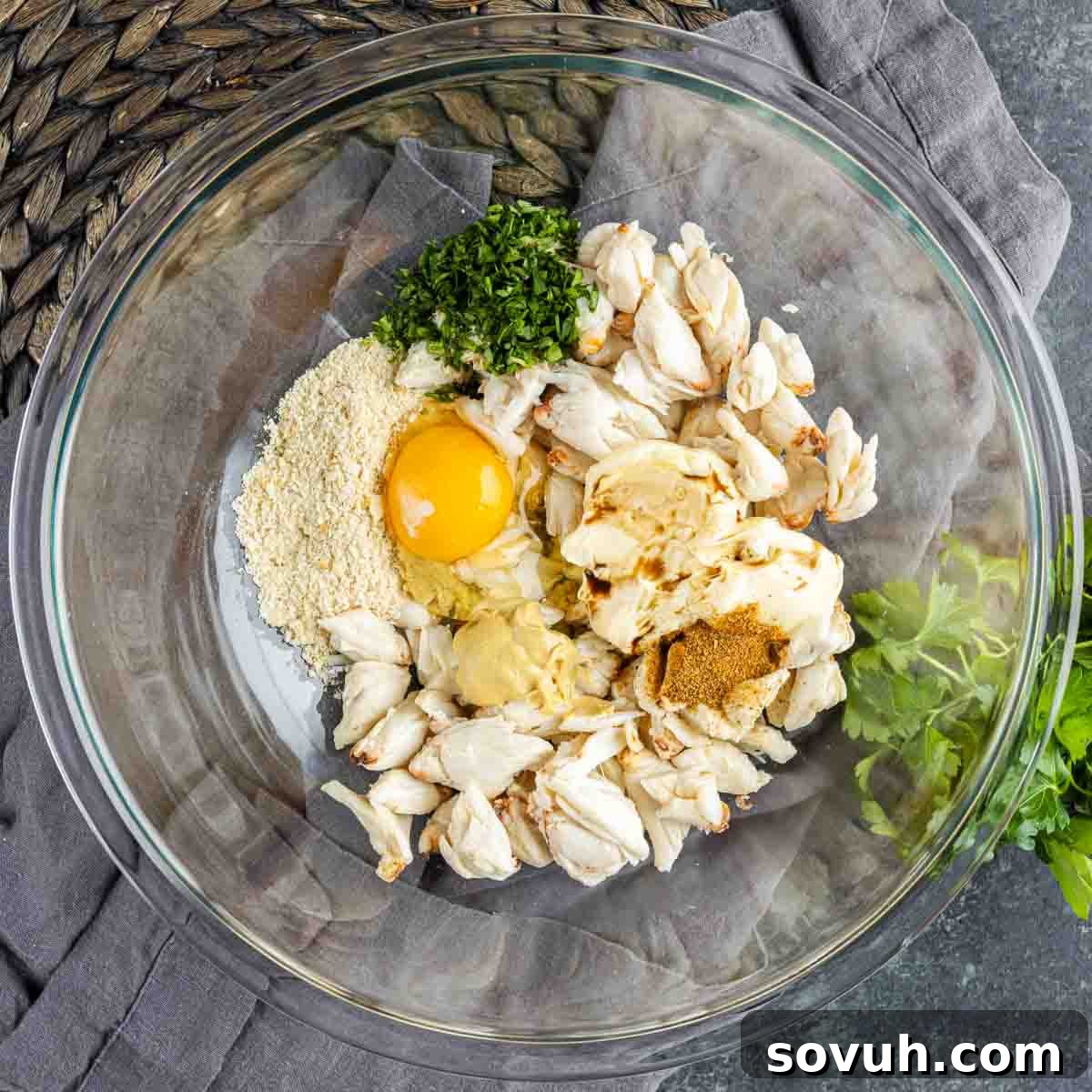 A glass bowl filled with ingredients for Maryland Crab Cakes
