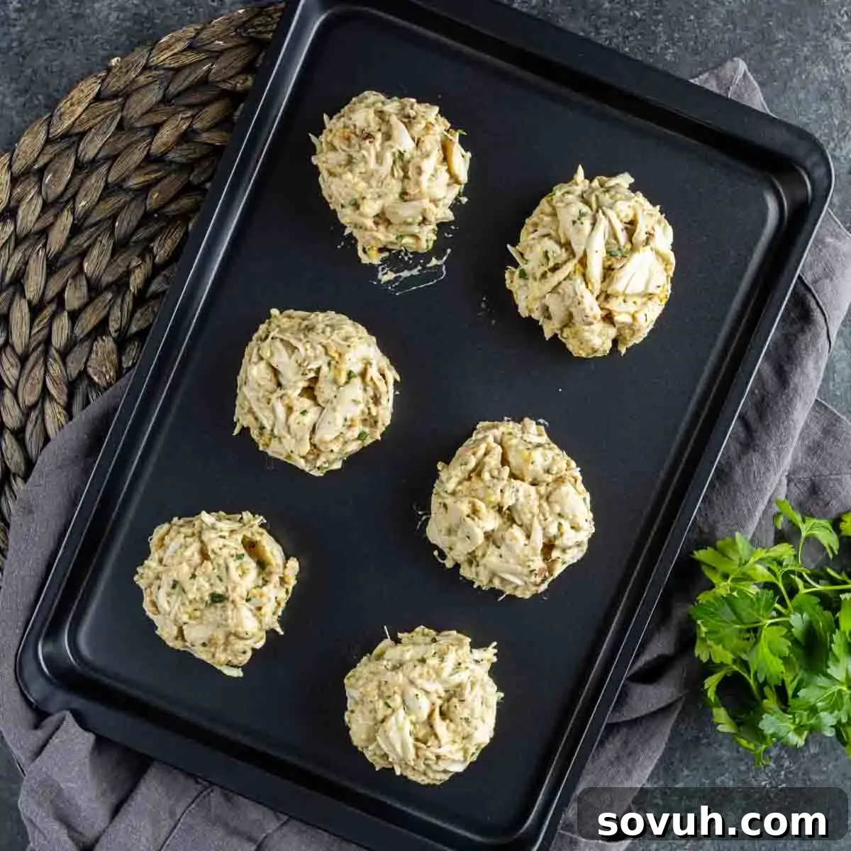 A baking sheet with a tray of Maryland Crab Cakes on it.