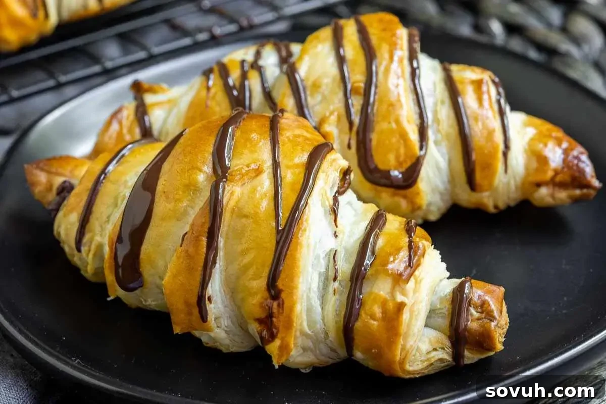 Freshly baked croissants with chocolate drizzle served on a black plate to celebrate Mother's Day.